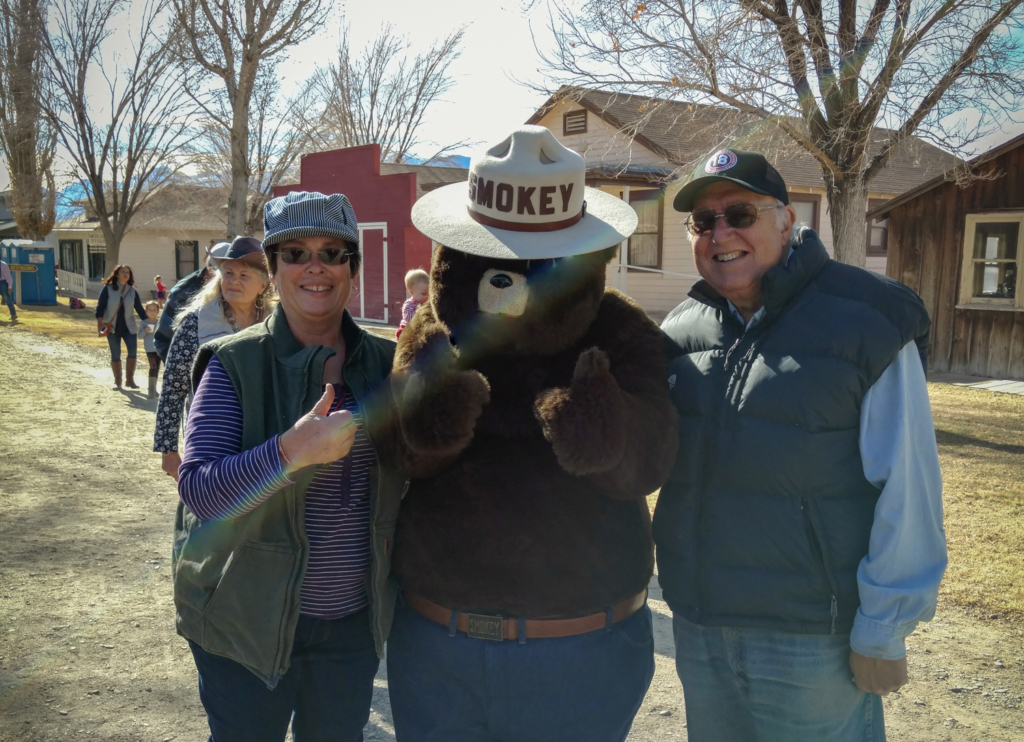ESLT volunteer couple Roberta Lagomarsini and Pete Pumphrey pose with Smokey the Bear.